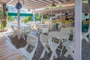 a group of tables and chairs in a restaurant at Лозенец Резорт in Lozenets