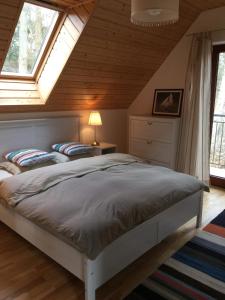 a bedroom with a bed and two windows at Domek Wakacyjny Na Złotych Wydmach in Międzywodzie