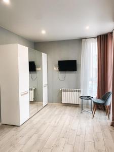 a living room with a television and a table at Apartments Domovik Стильна квартира, Миру 11 c кв 2 in Mukacheve