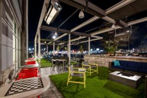 a rooftop patio with colorful chairs and tables at night at Home2 Suites By Hilton Lumberton in Lumberton