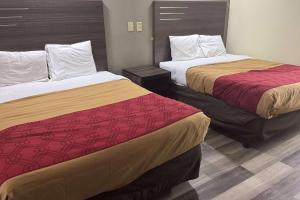 two beds in a hotel room with two beds at Super 8 by Wyndham Jackson MS Near the Fairgrounds in Jackson