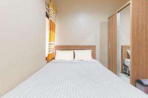 a bedroom with a white bed with two pillows at The Lavana Incottage Inkoppabri Puncak in Kopo 2 +86 photos