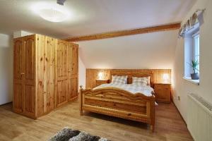 Un dormitorio con una gran cama de madera y una ventana en Holiday Home Osada, en Černý Důl