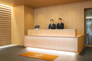 大阪谷町君 HOTEL 恵美須町72的两个穿着西装的人站在接待台