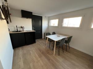 una cucina e una sala da pranzo con tavolo e sedie di Le Calais Wilson 4, 2-4 Pers a Calais Altre 11 foto