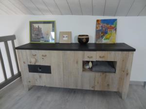 a wooden cabinet with a black counter top in a room at La Pointe D'Yvoire in Yvoire