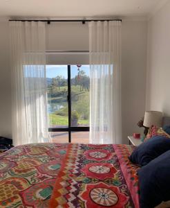 a bedroom with a bed and a large window at Circle of Light Retreat in Kangaroo Gully +2 photos