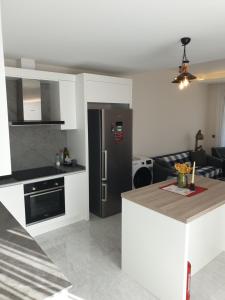 una cucina con frigorifero nero e tavolo di S Villa City a Çeşme