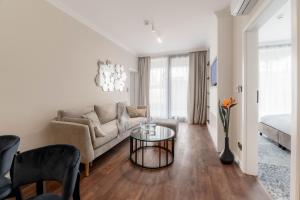 una sala de estar con un sofá y una mesa en Central Park Mielno by Solarento, en Mielno
