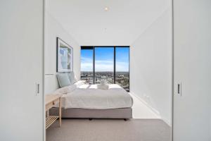 a bedroom with a bed and a large window at Brand new Luxurious 1 Bedroom Perth CBD in Perth