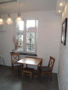 オルシュティンにあるApartament Staromiejskaの窓のある部屋(テーブル、椅子付)