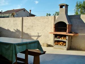 a outdoor pizza oven with a table and a table sidx sidx at Pave Apartment in Betina