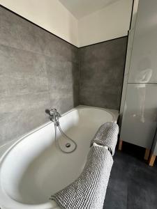 a white bath tub in a bathroom with a shower at THE120 work or holiday home in Comines +32 photos