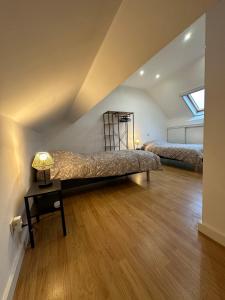 een slaapkamer op zolder met 2 bedden en een tafel met een lamp bij THE120 work or holiday home in Comines