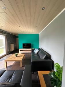 een woonkamer met een zwarte bank en een tv bij THE120 work or holiday home in Comines