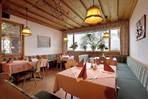 a restaurant with tables and chairs in a room at Gasthof Mairwirt in Schwendt