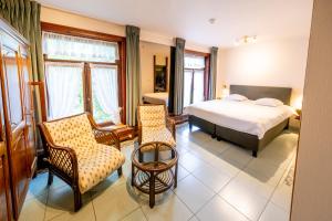 a bedroom with a bed and chairs in a room at Kasteel van Nieuwland in Aarschot +26 photos