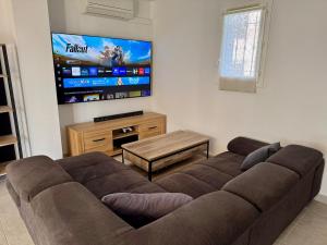 a living room with a couch and a flat screen tv at Maison 3 chambres avec jardin et spa in Les Arcs sur Argens