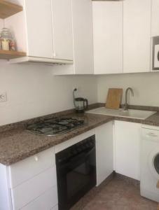 a kitchen with white cabinets and a stove top oven at Habitación privada LA ALCAZABA A TUS PIES in Almería