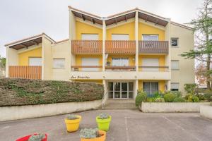a large yellow building with plants in front of it at Le Pré Catelan in Saint-Georges-de-Didonne
