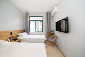a hotel room with two beds and a tv at Dengba Inn-Fengqiao Road Subway Station Global Harbor Branch in Shanghai +81 photos