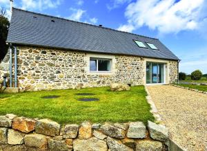 a stone house with a stone wall in front of it at Maison Le Rohel. in Pleubian +9 photos