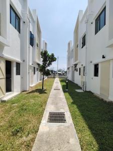 a walkway between two buildings with a tree in the middle at Cosy Townhouse in Tasek Gelugor in Ara Rendang