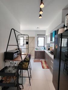 a kitchen with a table and a dining room at Cosy Townhouse in Tasek Gelugor in Ara Rendang