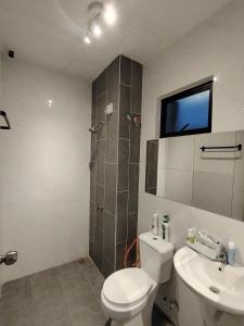a bathroom with a toilet and a shower and a sink at Cosy Townhouse in Tasek Gelugor in Ara Rendang