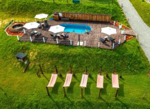 an aerial view of a pool with chairs and umbrellas at Chata w Bieszczadzie SPA apartamenty i domki z podgrzewanym basenem in Polańczyk +201 photos