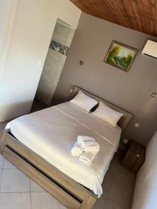 a bedroom with a bed with two towels on it at Bungalow Sainte-Anne in Sainte-Anne