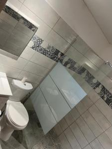a bathroom with a toilet and a glass shower at Bungalow Sainte-Anne in Sainte-Anne