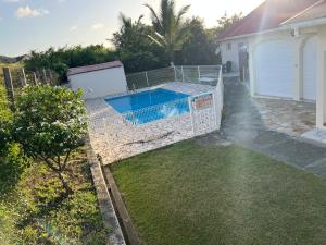 a backyard with a swimming pool in a yard at Bungalow Sainte-Anne in Sainte-Anne
