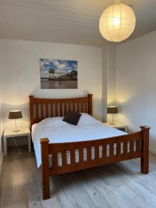 a bedroom with a wooden bed and two tables and a lamp at Maison 47m2 meublée 200m plage in La Bernerie-en-Retz