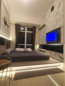 ein Schlafzimmer mit großem Bett und Fernseher in der Unterkunft Beautifull Vasanta Innopark Apartment 1BR -MM 2100 Cikarang Bekasi in Jarakasta