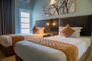a hotel room with two beds and a window at New Ambassador Hotel in Harare +36 photos