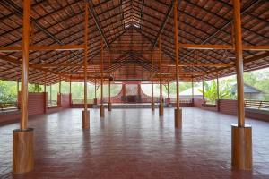 TaliparambaにあるBhavani Sarvashala - Holistic Wellness, Ayurveda & Physiotherapy Centreの大きなパビリオン(木製の柱と床付)