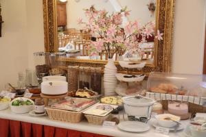 a table with a buffet of food and a mirror at Hajdú Kastély Hotel in Hajdúszoboszló