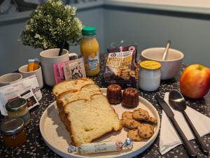 a table topped with a plate of bread and cookies at Le Logis d'Origine. in Marly-le-Roi