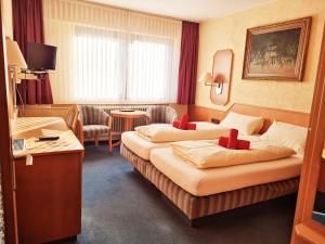 a hotel room with two beds in a room at Hotel-Barbarossa-Garni bei Hanau in Rodenbach +18 photos