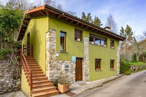 a yellow and green house with stairs on it at La Ensertal en Ribadesella in Linares