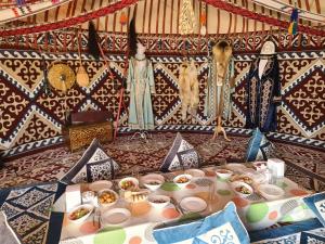 a table with plates and bowls of food on it at Visitor Center Sartas in Ashchimuryn
