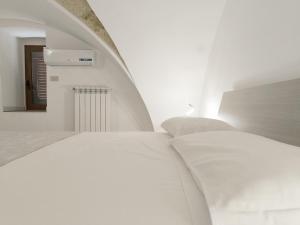 a white room with a bed and a staircase at Dimora Paolo a Ugento pochi minuti al Mare Salento in Ugento