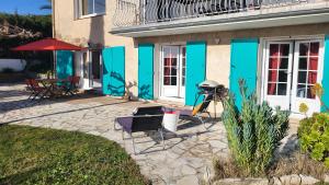 een huis met blauwe deuren en een grill op een patio bij Appartement La Marina in Fréjus