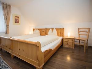 1 dormitorio con 1 cama grande de madera y 1 silla en Welcome in - vakantiewoningen in Winterberg met panoramisch uitzicht, en Winterberg