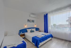 a bedroom with two beds and a large window at Siyanie Kiten in Kiten +36 photos