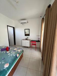 Un dormitorio con una cama, una mesa y una silla. en B-local mong guest house, en Kuta Lombok