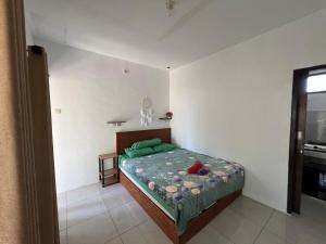 Un dormitorio con una cama con almohadas verdes. en B-local mong guest house, en Kuta Lombok