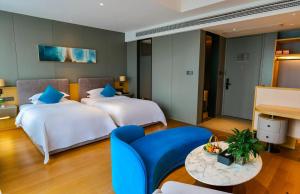 a hotel room with two beds and a table at SSAW Boutique Hotel Wenzhou Dexin in Wenzhou +45 photos