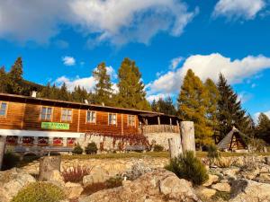 a large wooden building with trees in the background at Bungalovy Baranec in Žiar
